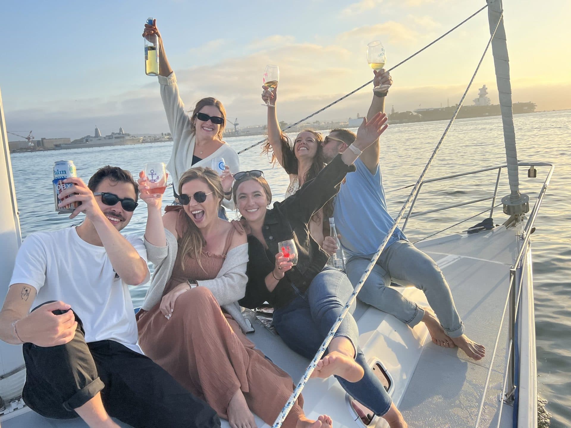 Friends toasting champagne at sunset on a holiday charter on San Diego Bay