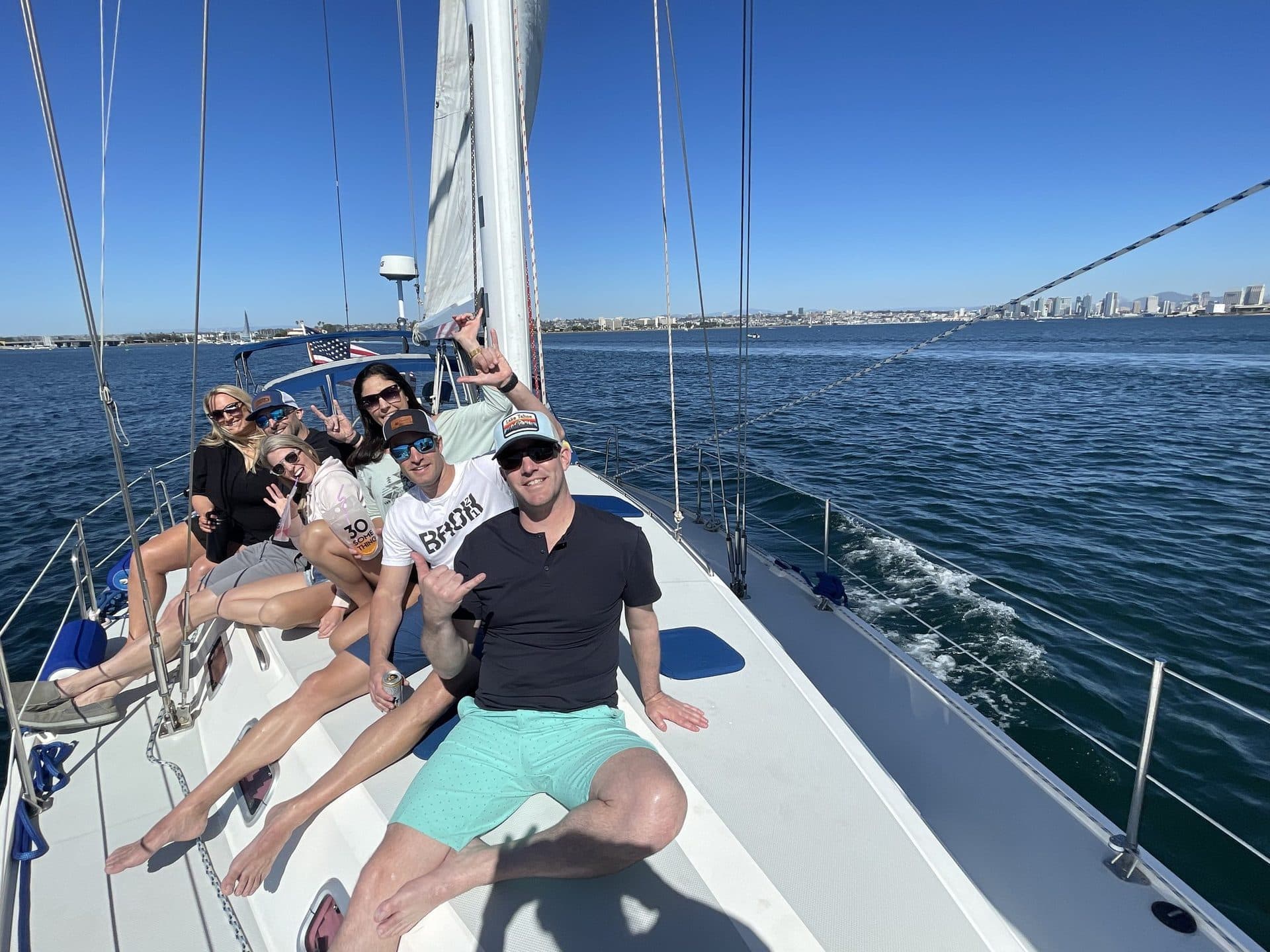 Friends lounging on the foredeck of the Mojave under sail