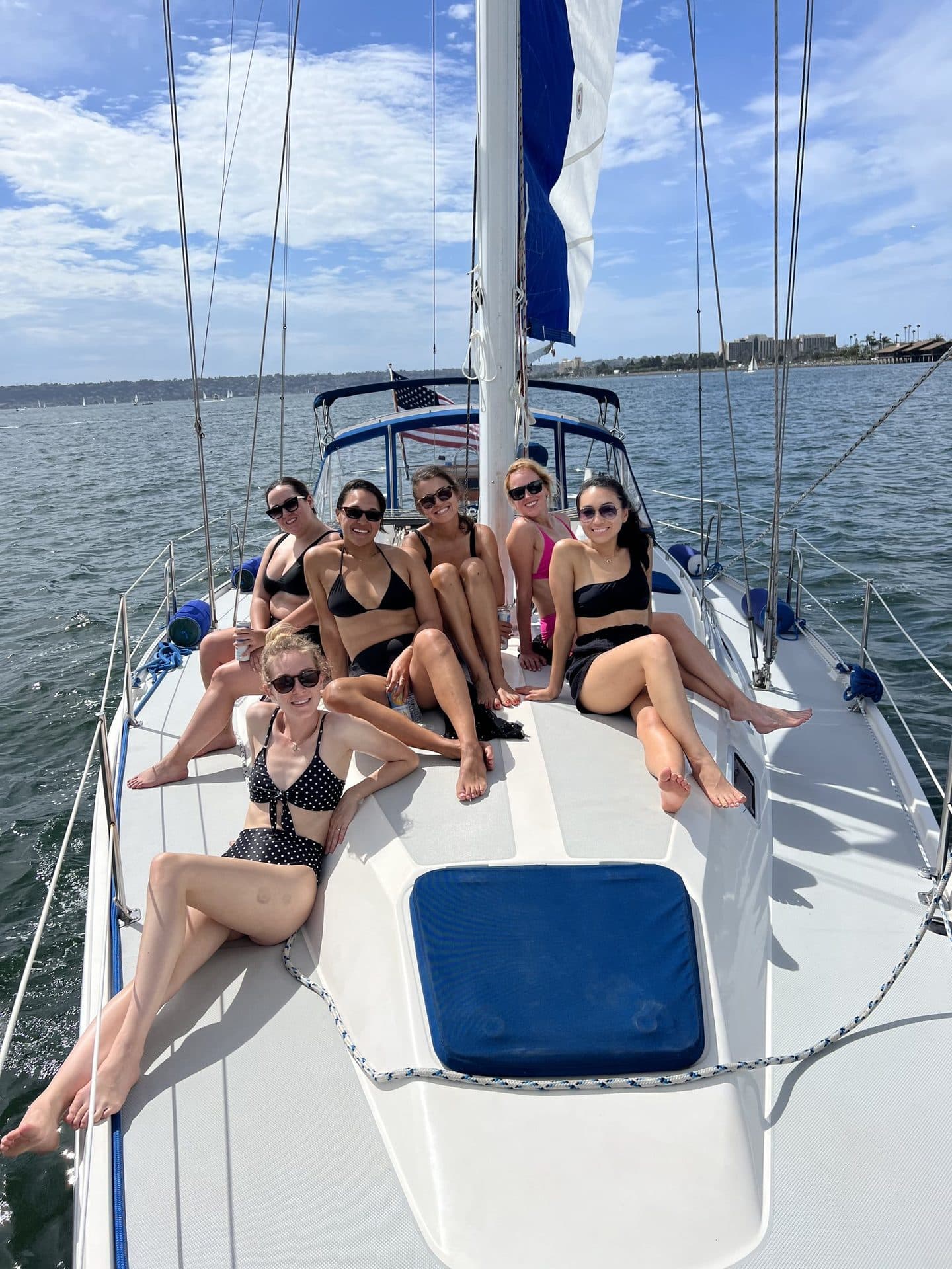 A group relaxing on deck on a 4-hour Sail & Swim charter in San Diego