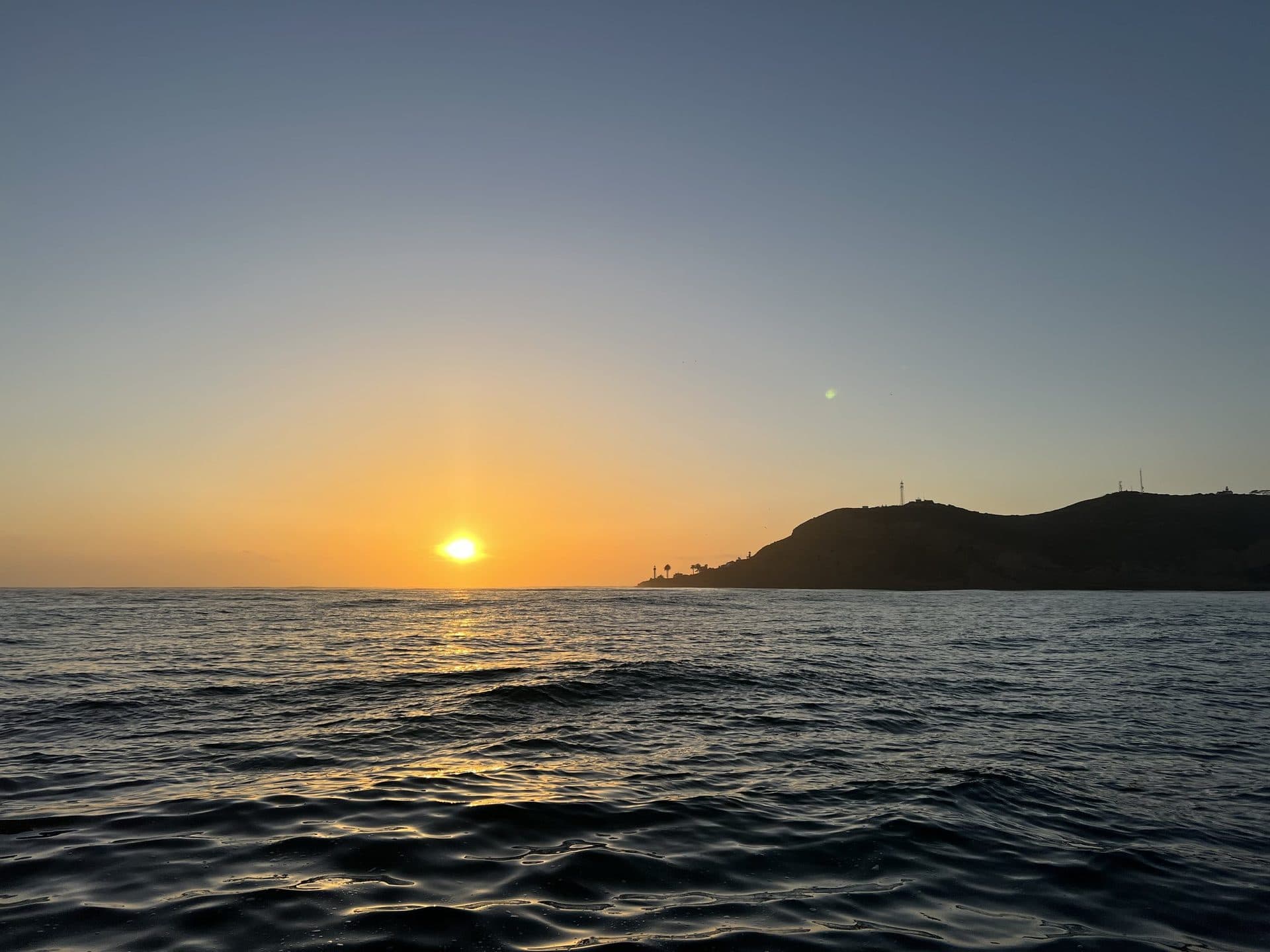 The sun setting over the Pacific beyond San Diego Bay on a memorial charter